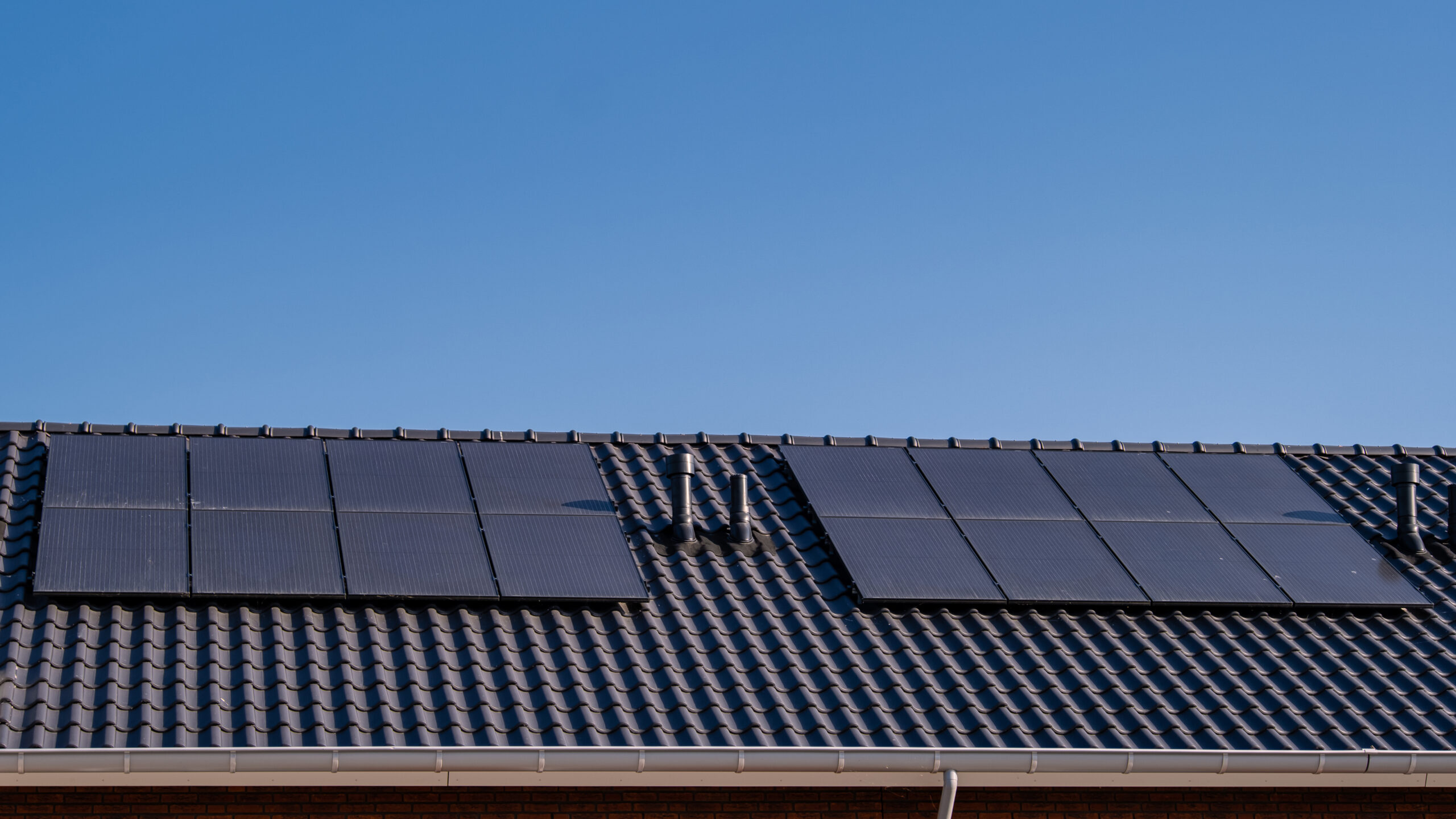 Newly build houses with solar panels attached on the roof against a sunny sky